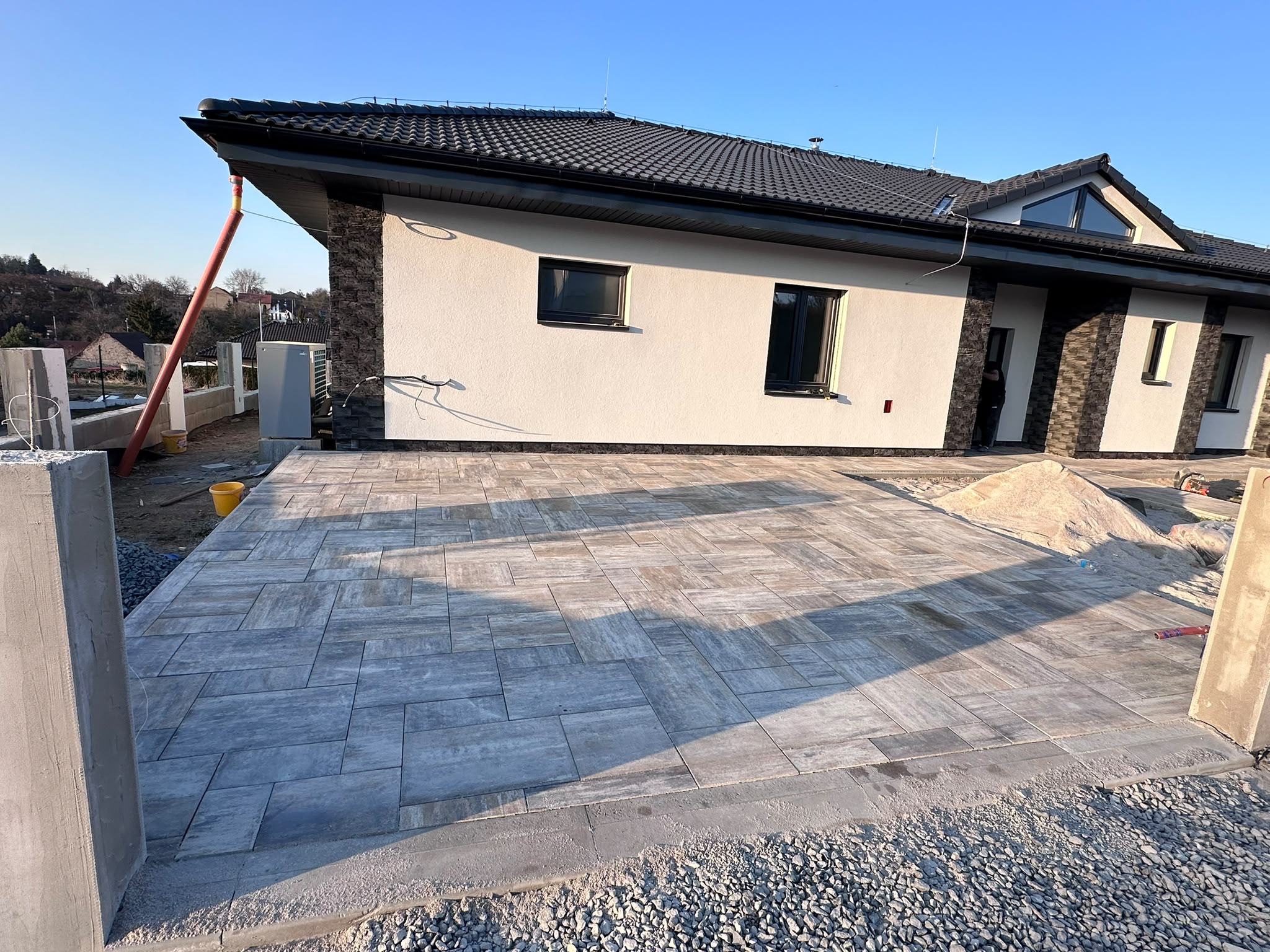 Dokončená příjezdová a parkovací plocha z velkoformátové dlažby před novostavbou bungalovu