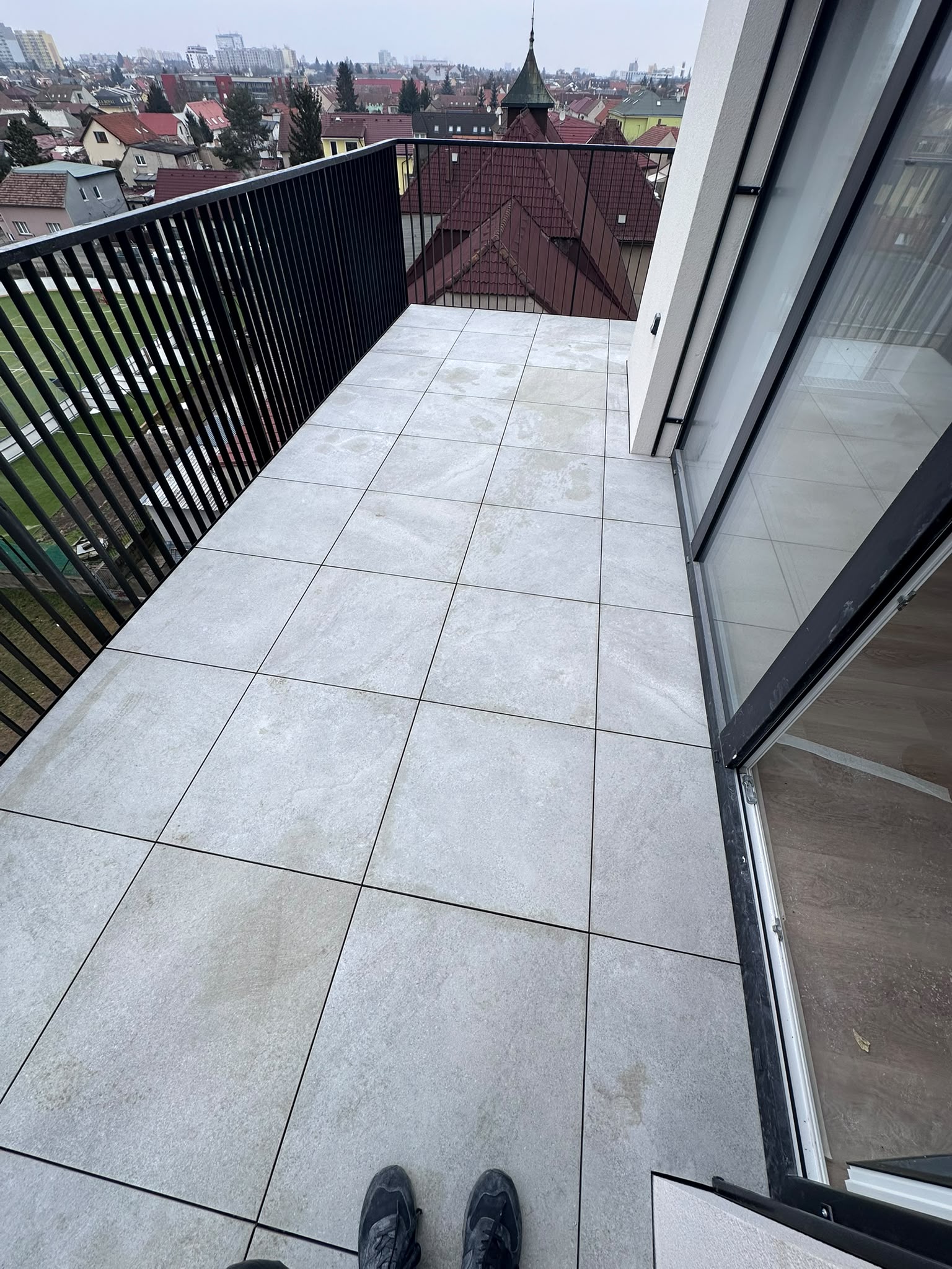 Balkon s velkoformátovou dlažbou v městské zástavbě